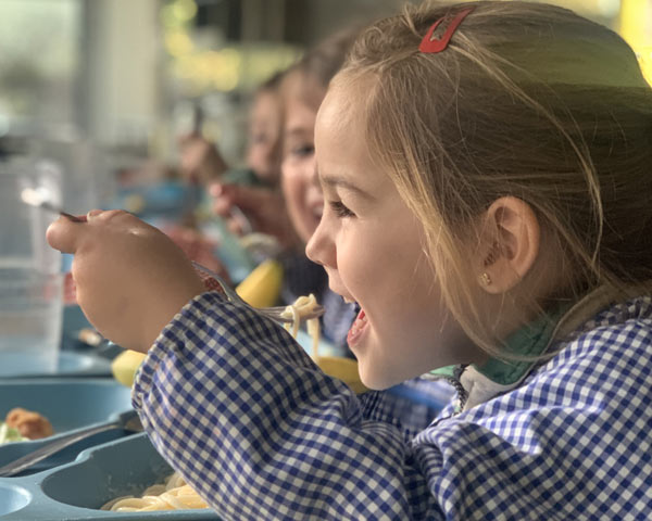 Infant menjant al menjador de l'escola